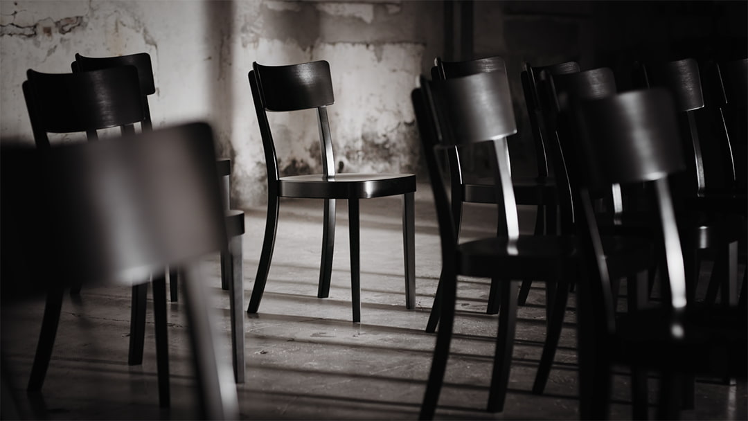 Still of the horgenglarus film showing black classic horgenglarus chairs in a room with concrete walls and floor.