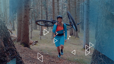Still of the rtr broadcast design showing a mountainbiker carrying her bike on the back while walking through the forest overlayed by white rectangles and a blue color gradient.
